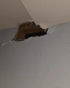 A ceiling opened up to reach a leaking water line above it