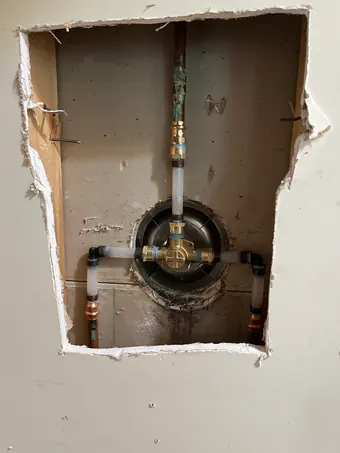 During: the shower valve reached through an opening in the wall.