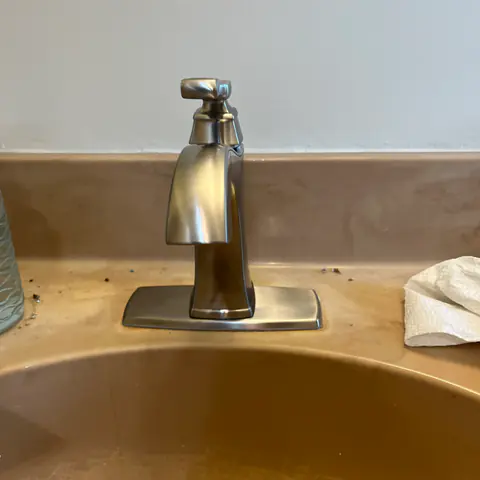After: the new brushed-nickel faucet on the same sink.
