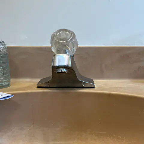 Before: the old chrome faucet with a clear knob handle.