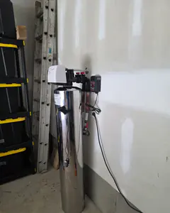The new stainless water filter installed against a garage wall.